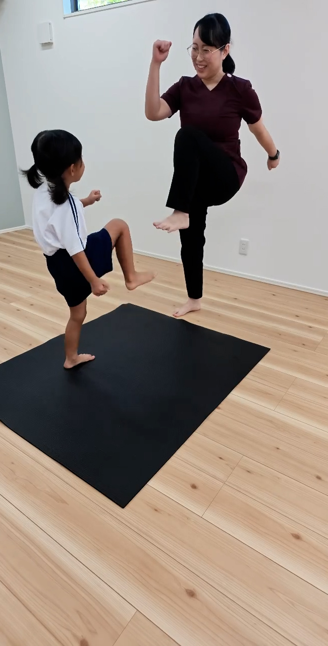 インストラクターと身体を動かすお子さん